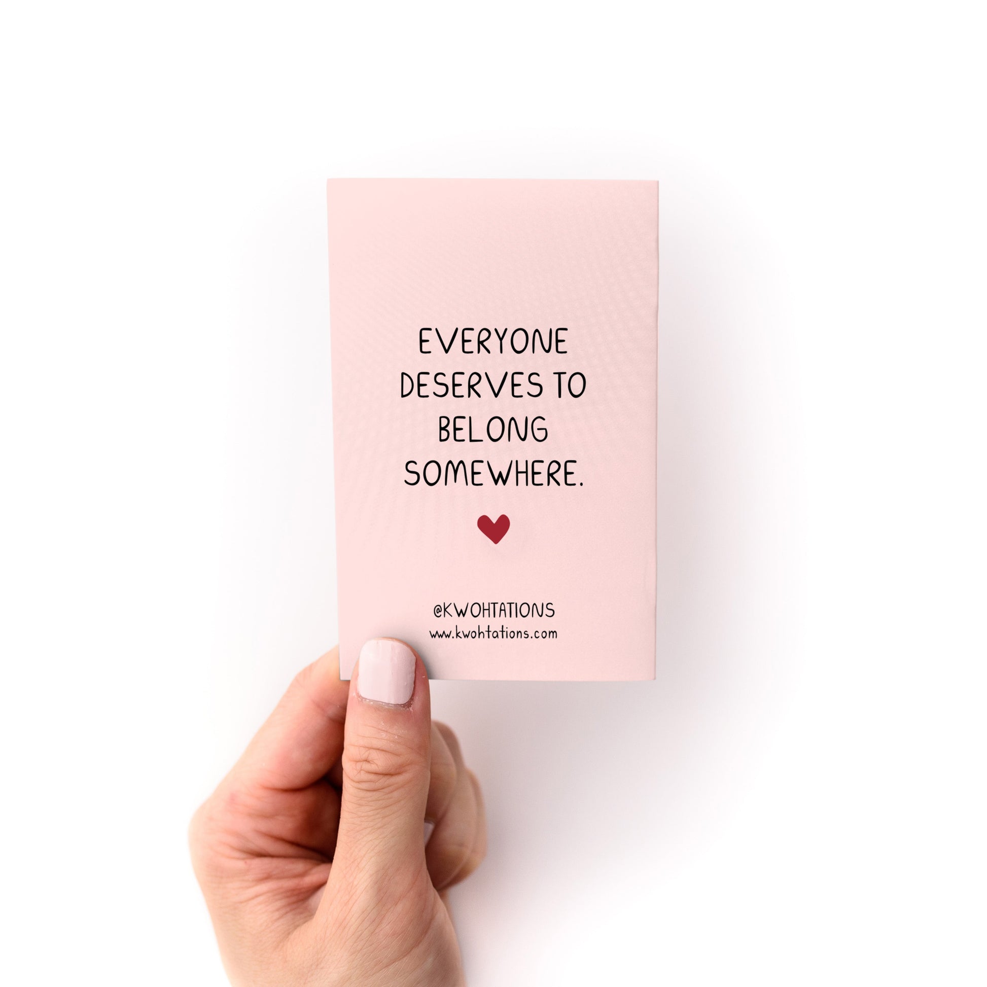 On Belonging (A Tiny Manifesto) Zine held by hand showing message about belonging on pink cardstock