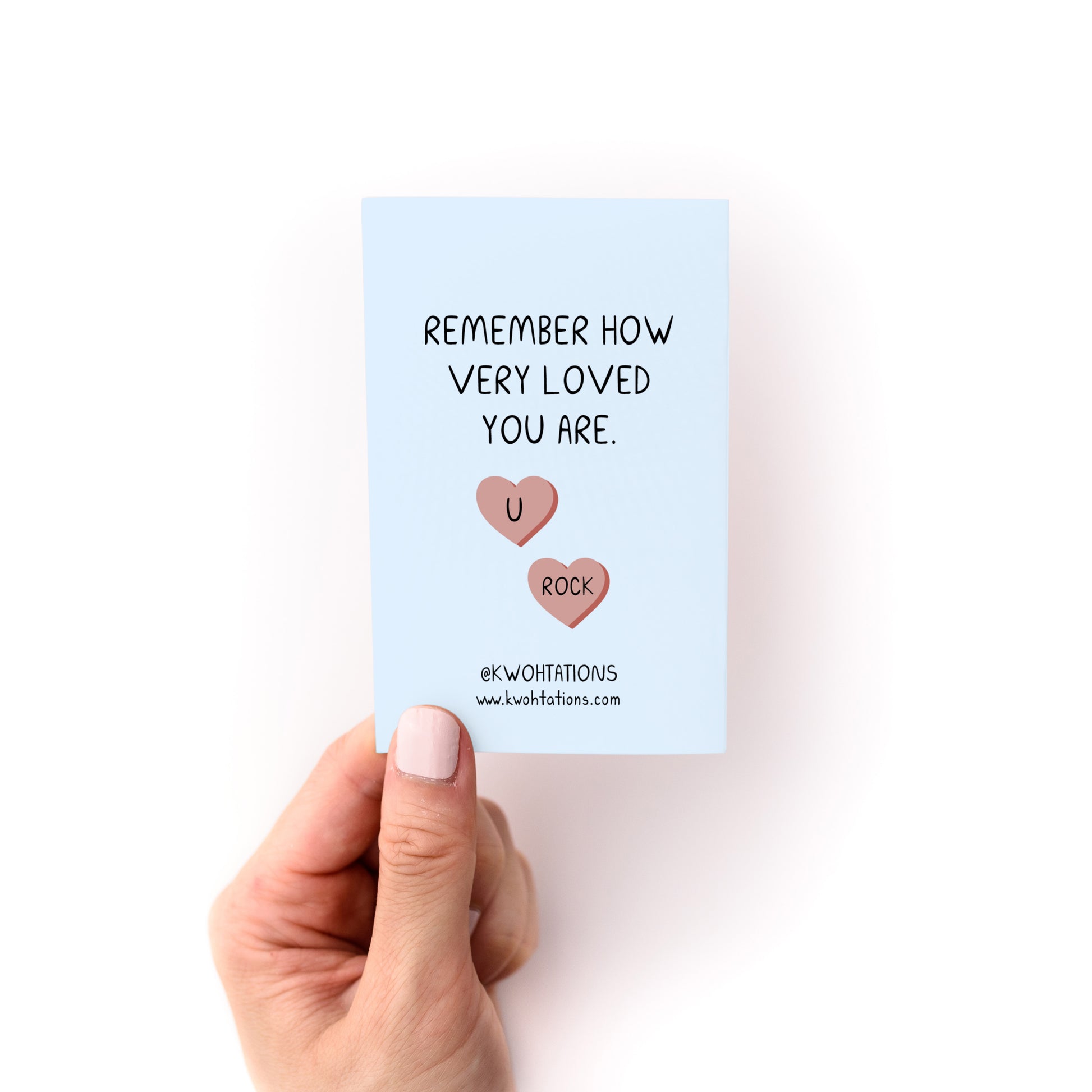 Hand holding a card from Things to Do When You're in a Depressive Spiral Zine reading remember how very loved you are.