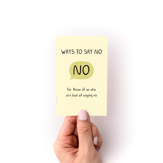 Hand holding the "Ways to Say No Zine" with a yellow cover and simple text about saying no.