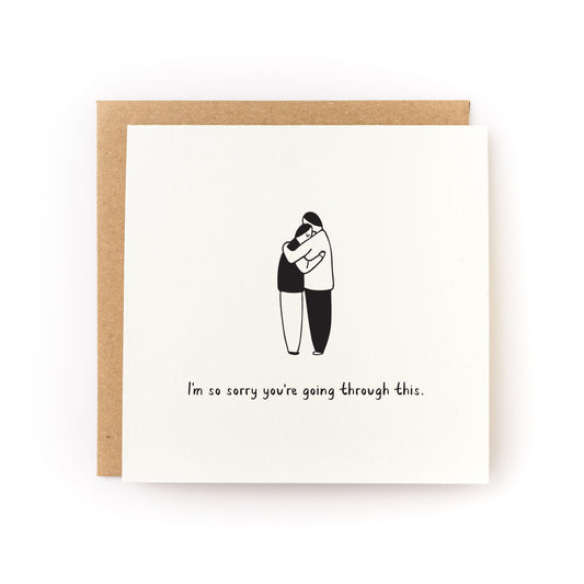 Sorry You're Going Through This Letterpress Card showing two people hugging with sympathy message on white cardstock.