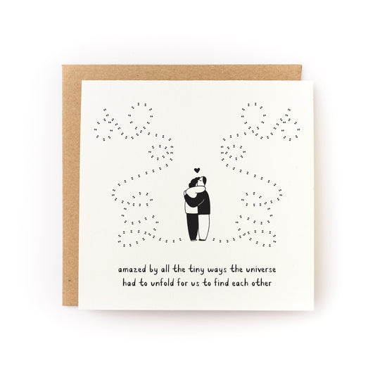 Universe Unfolds Letterpress Card showing a couple hugging with a starry universe design on white folded cardstock