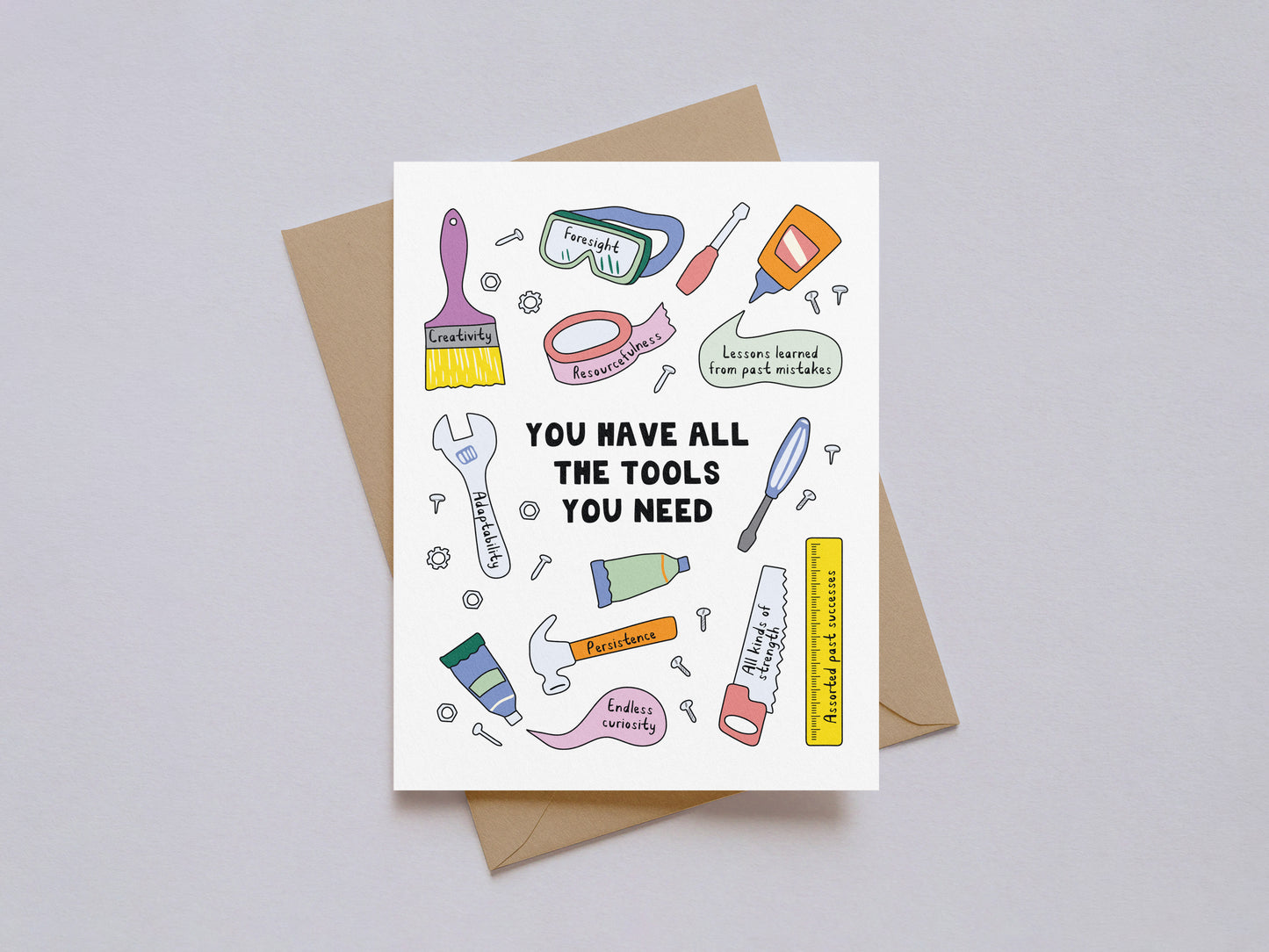 Encouragement card with illustrated tools and motivational phrases on white background with kraft envelope behind