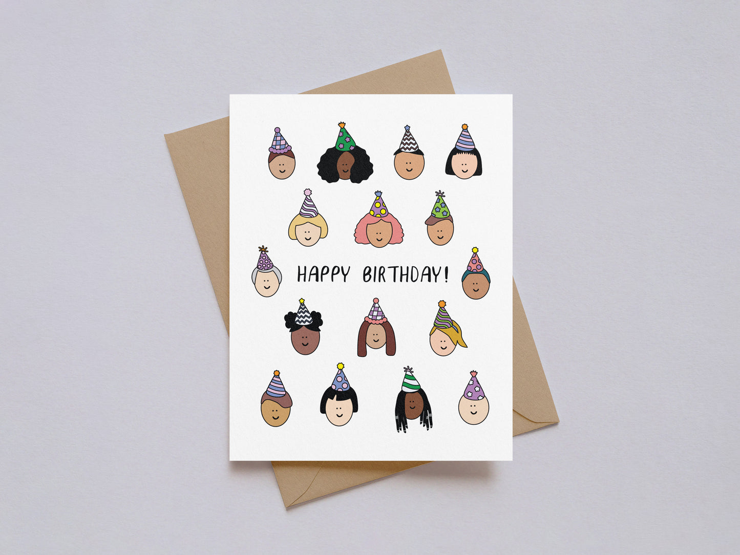 Birthday card featuring diverse happy faces wearing party hats and handwritten "Happy Birthday!" text on white background