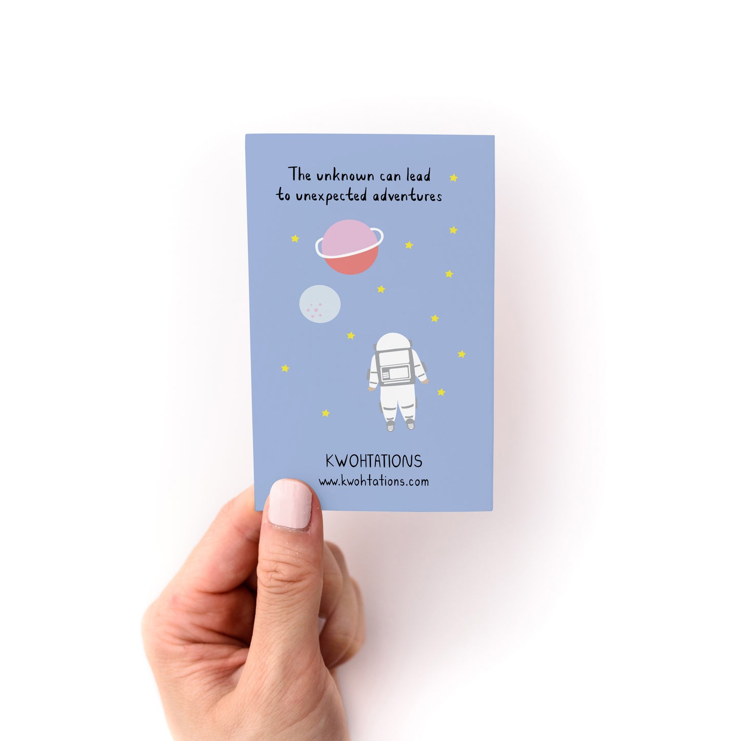 Hand holding a card with astronaut and planets titled Reminders for Uncertain Times Zine by Kwohtations
