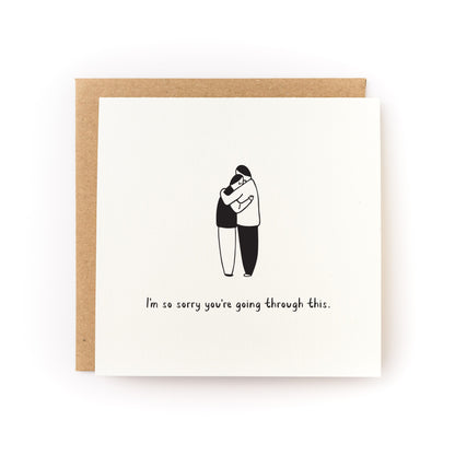 Sorry You're Going Through This Letterpress Card showing two people hugging with sympathy message on white cardstock.
