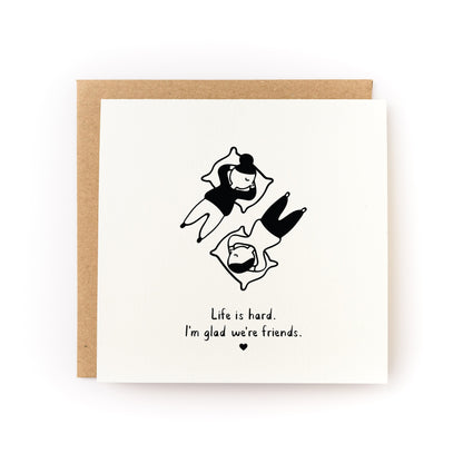 I'm Glad We're Friends Letterpress Card with black illustration and message on white cardstock paired with kraft envelope.