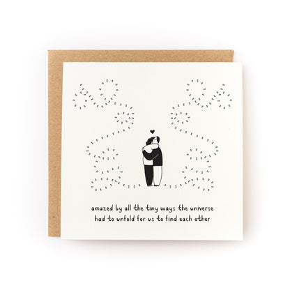 Universe Unfolds Letterpress Card showing a couple hugging with a starry universe design on white folded cardstock