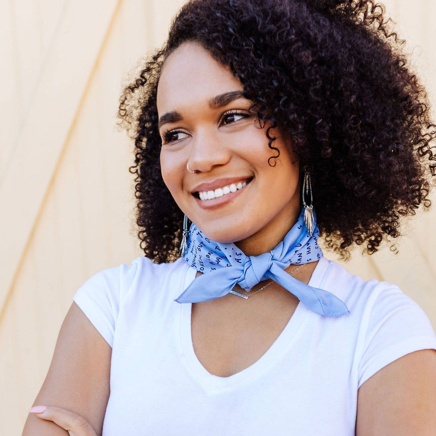 Persona wearing blue Love as Well Bandana that is featured tied in the front