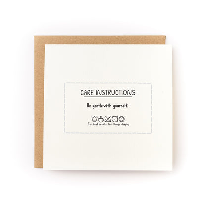 Care Instructions Letterpress Card reading Be gentle with yourself with brown kraft envelope on white background