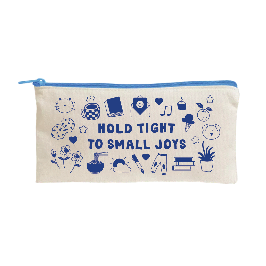 Beige fabric pouch with a blue zipper, featuring blue illustrations including a cat face, coffee cup, book, smiley face envelope, music note, candle, ice cream, fruit, dog face, flowers, noodles, sun, paintbrush, pants, books, and a potted plant, surrounding the phrase "Hold Tight to Small Joys.