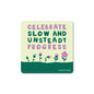 Square matte vinyl sticker with text "Celebrate slow and unsteady progress" above a row of pink flowers on green background