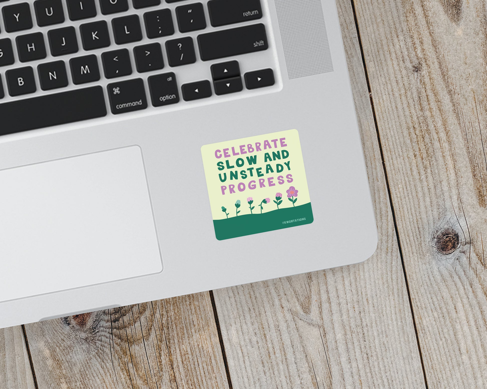 Square matte vinyl sticker on laptop with text "Celebrate Slow and Unsteady Progress" and small flower illustrations