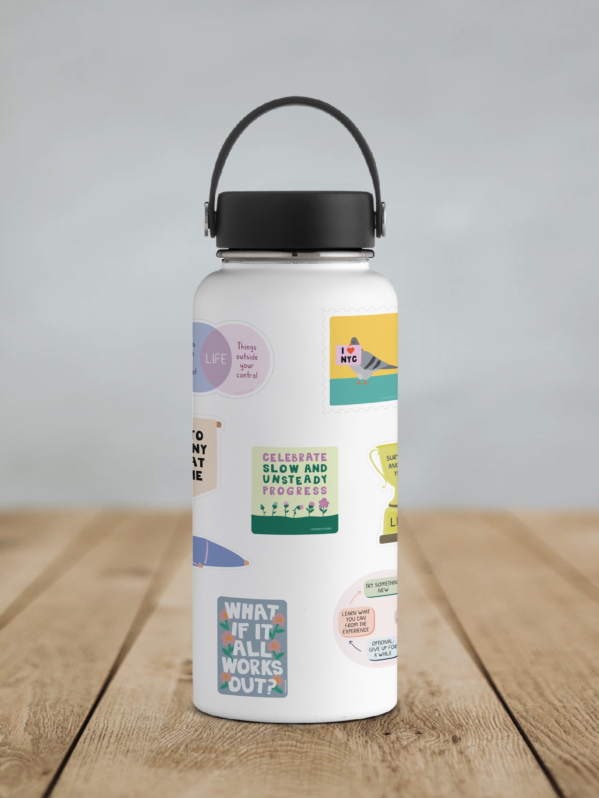 White water bottle with colorful motivational stickers including a Slow and Unsteady Progress vinyl sticker on wooden surface.