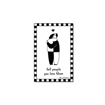 Minimalist black and white illustration of two people embracing with a small heart above them, surrounded by a checkered border and handwritten text saying "tell people you love them.