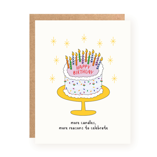 Illustrated birthday card showing a two-layer white frosted cake with colorful sprinkles and lit candles on a yellow cake stand, surrounded by golden starbursts and text reading "more candles, more reasons to celebrate.